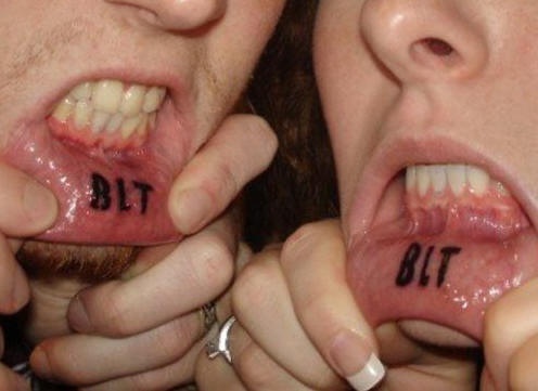 Tattoo mit drei großen Lettern &quotBLT" an der Lippe