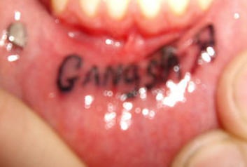 Tatuaje en el labio, gangsta, gángster, inscripción negro