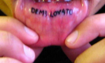 Tatuaggio sul labbro &quotDEMI LOVATO" a lettere piccole