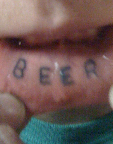 Einfach stilisiertes Tattoo &quotBeer" an der Lippe