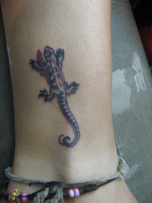 El tatuaje pequeño de una lagartija en 3d en la pierna