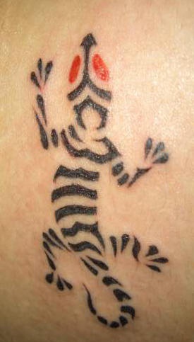El tatuaje de una lagartija negra rayada con ojos de color rojo