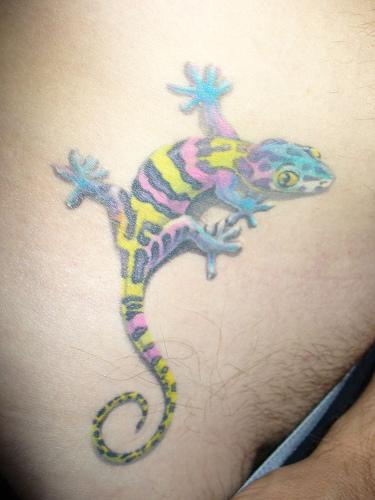 Colourful lizard tattoo on lower chest