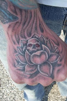 Lotus flower with skull tattoo on hand