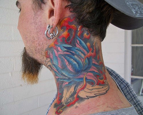 el tatuaje de una flor de loto con fuego hecho en color en el cuello