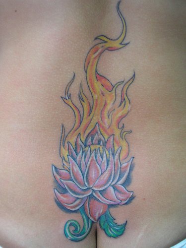 el tatuaje de una flor de loto enel fuego hecho en la espalda