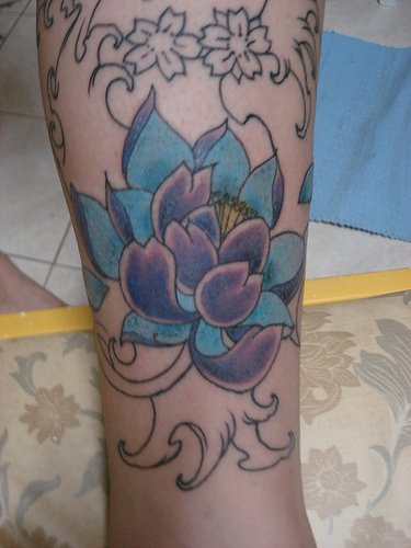 el tatuaje de una flor de lotode color azul y morado