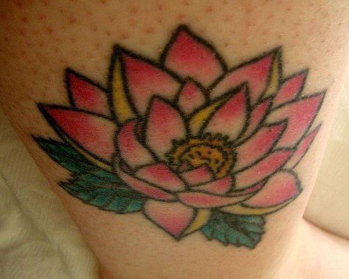el tatuaje de una flor de loto de color rosa hecho en la pierna