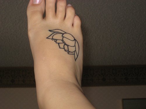 el tatuaje sencillo lineado de una flor de loto en el pie