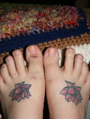 el tatuaje de dos flores de loto rojas, una en cada pie