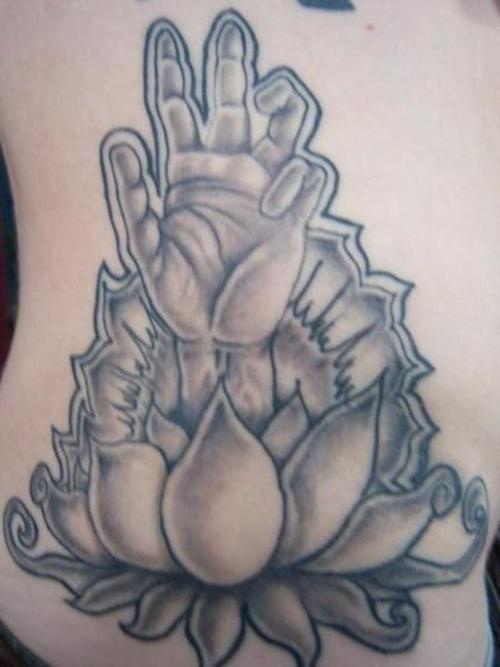 El tatuaje de una flor de loto con una mano humana en color negro