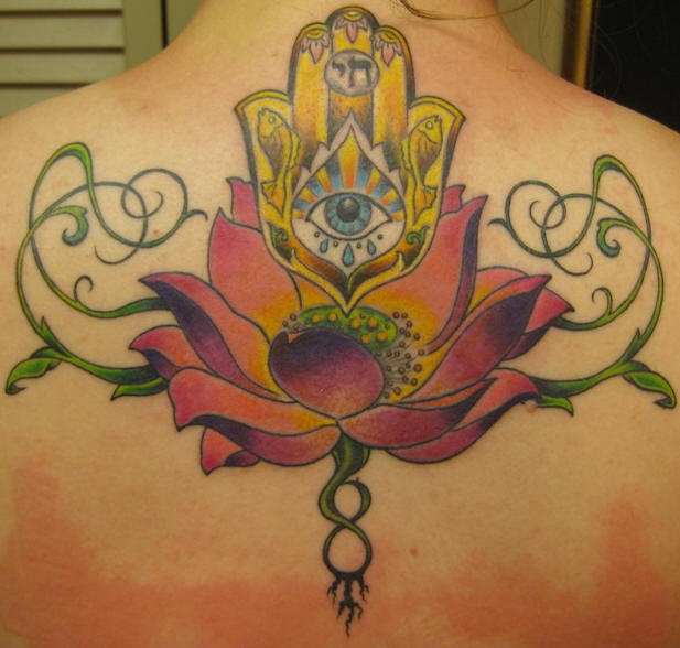 El tatuaje de flor de loto con el simbolo de la mano di fatima hecho en color en la espalda