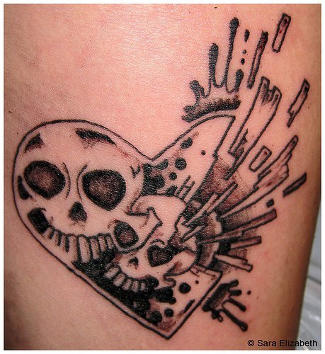 Broken heart with skulls in it tattoo