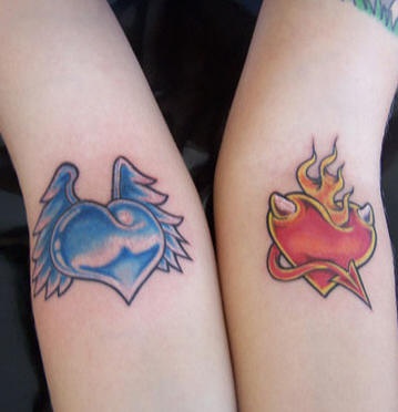 el tatuaje para la pareja de dos corazones  contrarios de color azul y otro rojo hecho en las manos