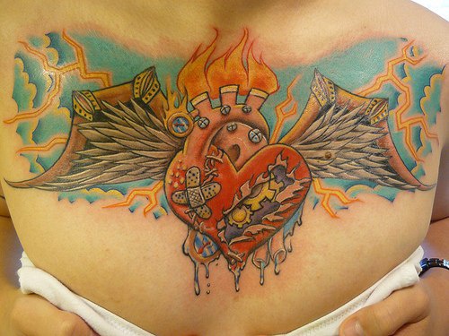 Sacred heart with wings in sky on chest