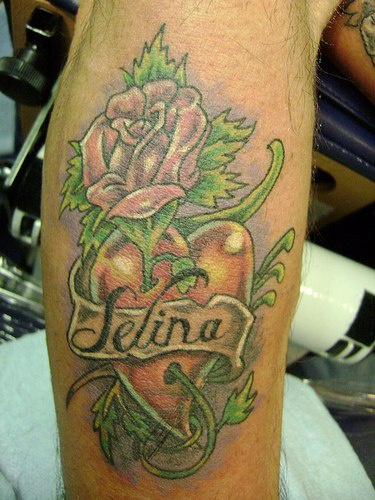 el tatuaje del nombre &quotselina" sobre un corazon rojo con una rosa