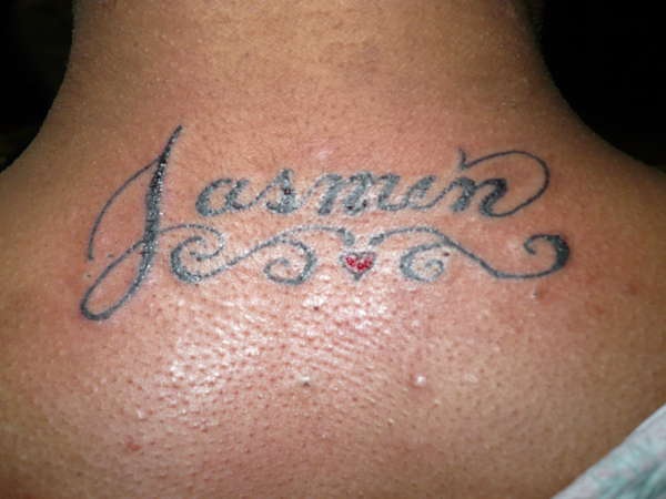 el tatuaje del nombre &quotjasmin" con una traceria hecho en la espalda