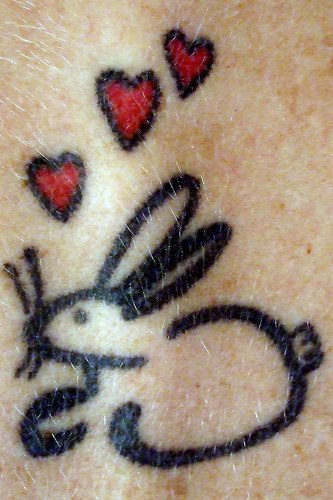 Rabbit with red hearts tattoo