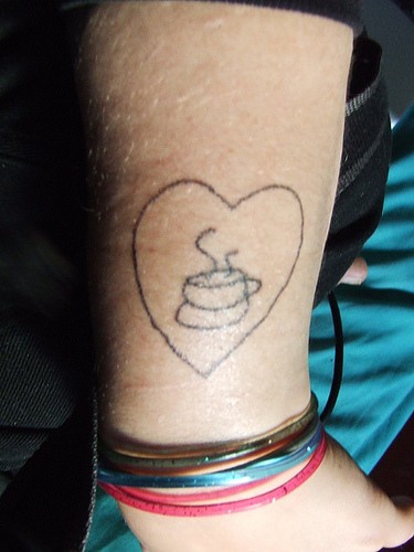 el tatuaje sencillo de un corazon con una taza de cafe adentro hecho en la mano