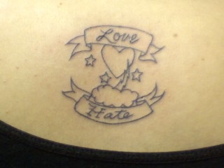 el tatuaje sencillo de un corazon en una nube con palabras &quotlove hate" &quotamor odio"