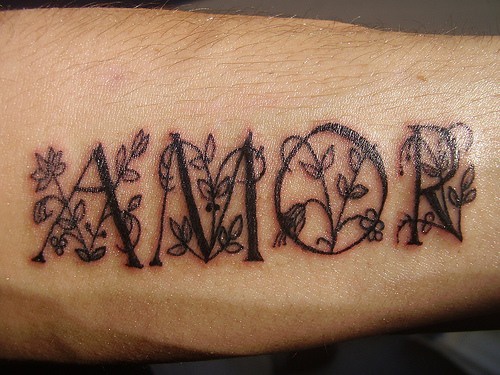 el tatuaje de la palabra &quotamor" con un entrelazado de flores hecho en color negro