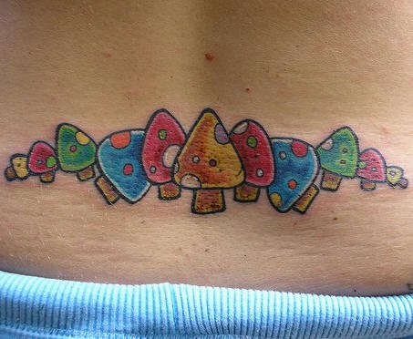 Tatuaje en bajo de espalda con setas iguales en color estilo infantil