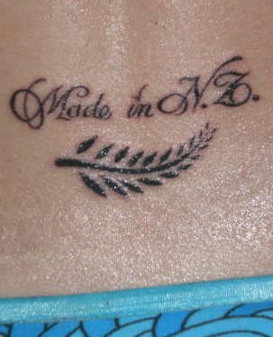 Lower back tattoo, feather and styled inscription