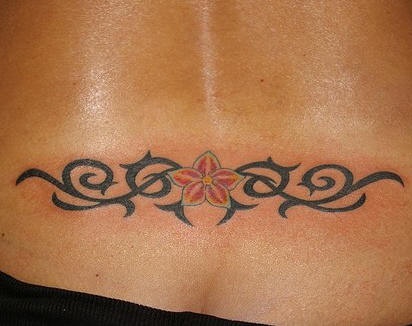 Lower back tattoo, red flower with curls long as wings