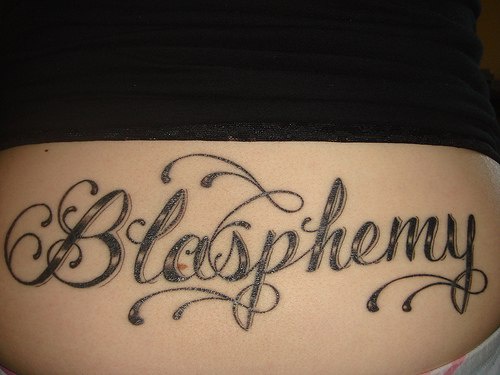 Tatuaje en el bajo de la espalda, blasphemy, con decoración