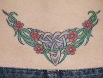 Tatuaje en el bajo de la espalda, tracería con flores en color