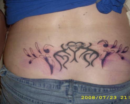 Lower back tattoo, three designed hearts and styled drops