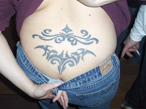 Lower back tattoo, black styled pattern. two parts