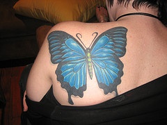 Large blue butterfly tattoo on shoulder