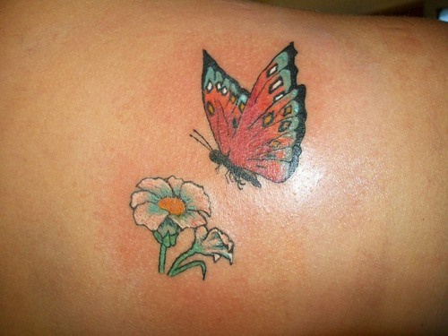 Lower back flower tattoo, flying beautiful butterfly