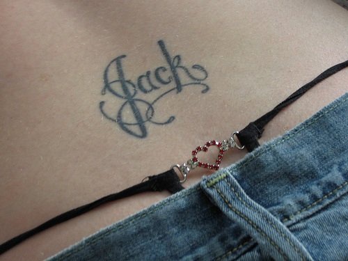 Lower back tattoo, jack, black curled styled name