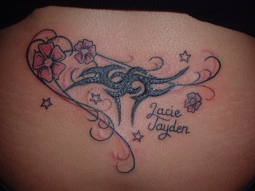 Tattoo &quotJacie Jayden" mit Schnörkeln in Schwarz , Blumen und Stgernen  am Becken