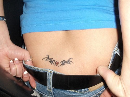 Lower back tattoo, little red heart decorated