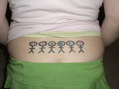 Le tatouage de bas du dos avec six petits midgets