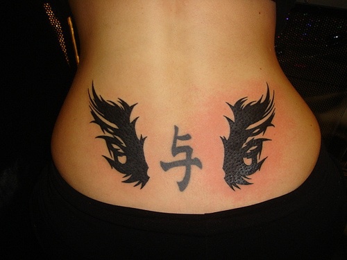 Lower back tattoo,black hieroglyph, styled with wings