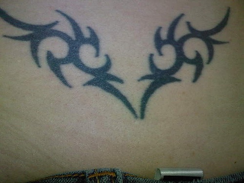 Lower back tattoo, decorated black wings