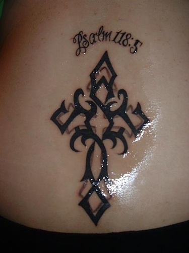 Tatuaje en el bajo de la espalda, en tinta negra, cruz, psalm 118:5