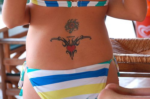 Lower back tattoo, heart and flower, the centres of patterns