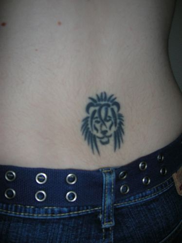 Lower back tattoo, black styled head of lion