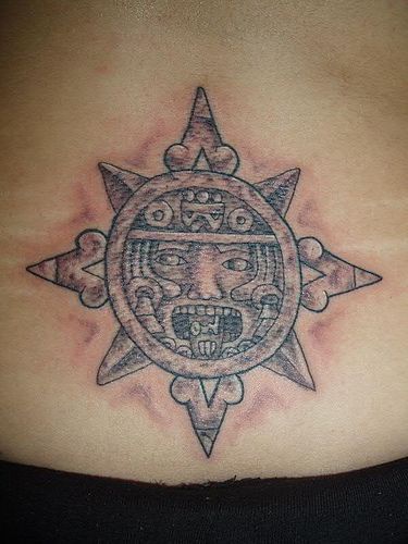 Il sole in stile tribale tatuato sulla lombo