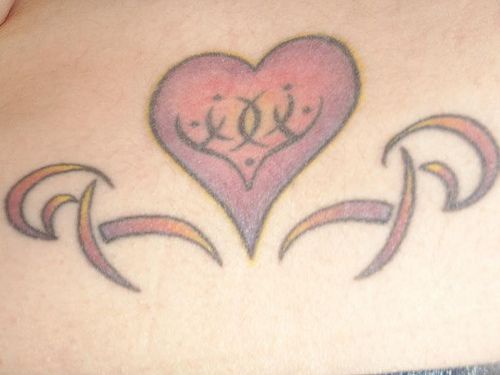 Tattoo von schönem Herzen mit Hieroglyphe am Becken