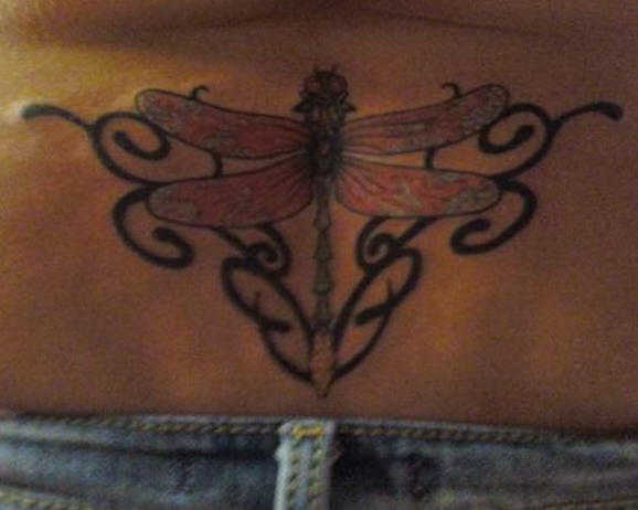 Tatuaje en el bajo de la espalda, libélula con tracería estilo tribal