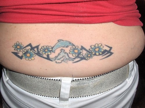 Tatuaje en bajo de la espalda en tinta azul, delfines entre olas marinas y flores