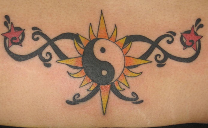 Tatuaje yin yang con sol y estrellas en color en la cintura