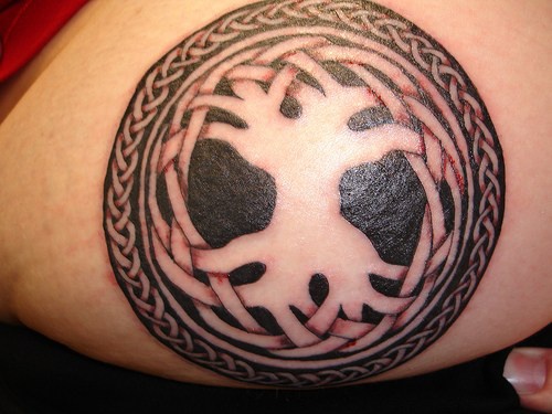Un rond noir mystique tatouage sur la hanche avec un signe fendu