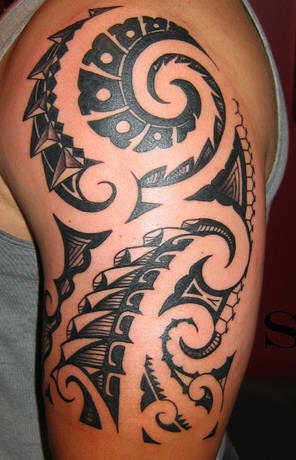 Tatuaggio non colorato sul braccio il disegno in stile tribale